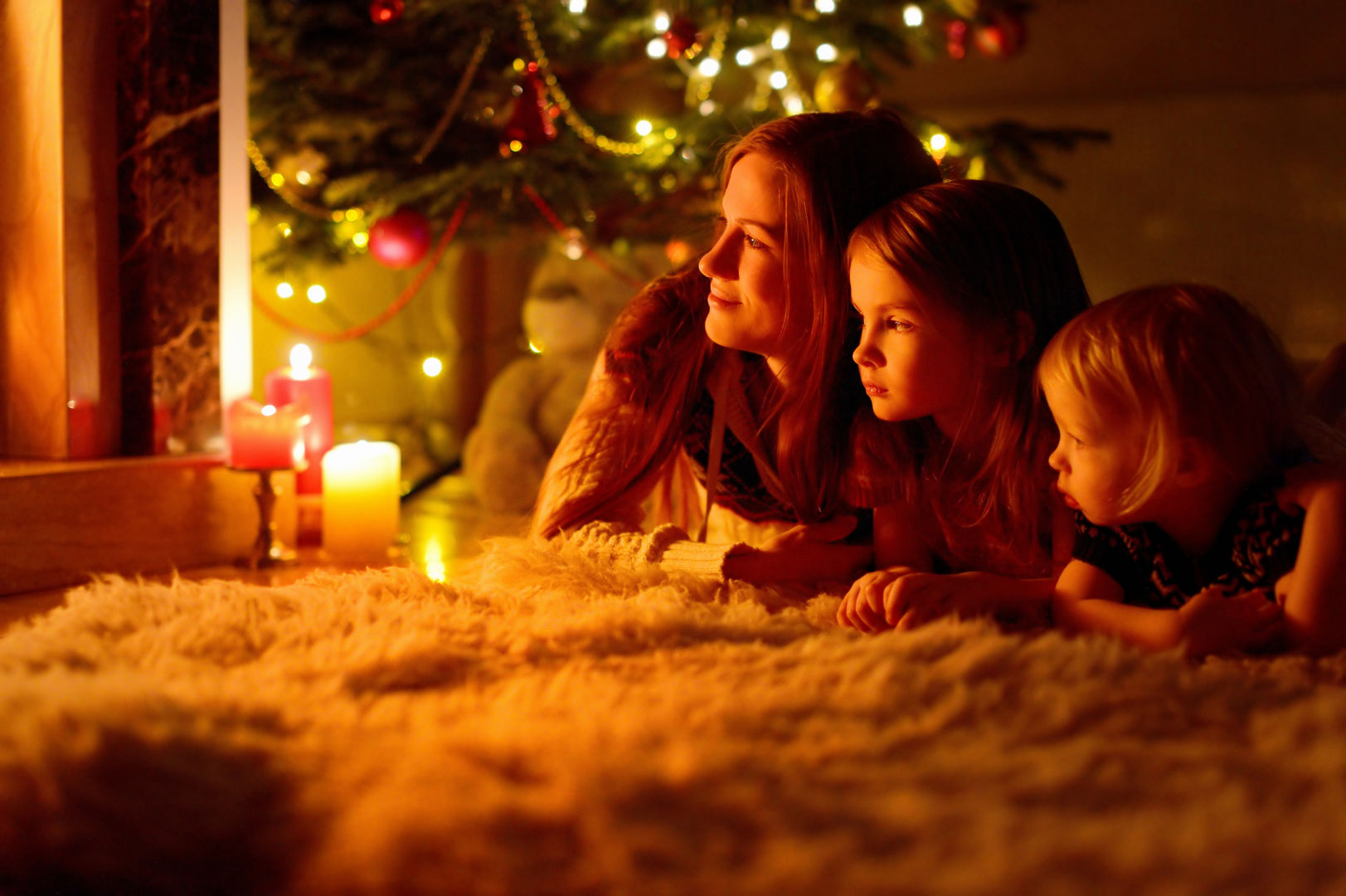 Weihnachtsstimmung mit Kindern unter beleuchtetem Christbaum